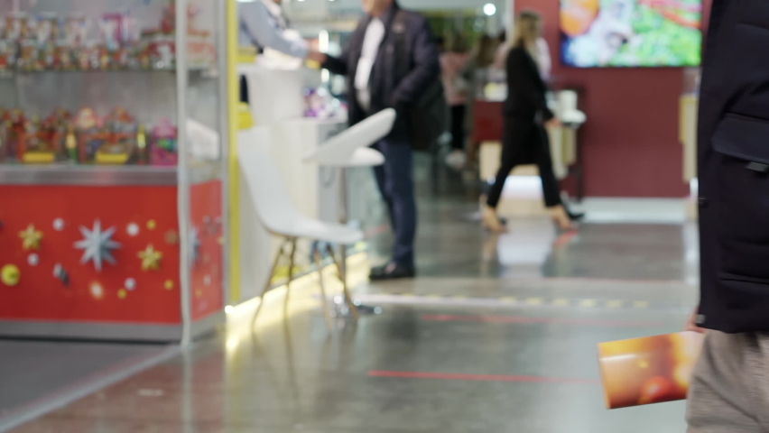 Anonymous people walk past a video camera that is filming them.