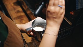 Barista steaming milk. barista prepares latte. coffee drink. latte. close-up. barista whips milk in a pitcher with hot steam from coffee machine. process of making milk foam. - Powered by Shutterstock - Get 15% off with code: PIKWIZARD15