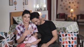 A smiling young couple with happy faces looking at the web camera - video call, nuclear Indian family. Busy parents talking online while little baby is sleeping - modern lifestyle, distant communic... - Powered by Shutterstock - Get 15% off with code: PIKWIZARD15