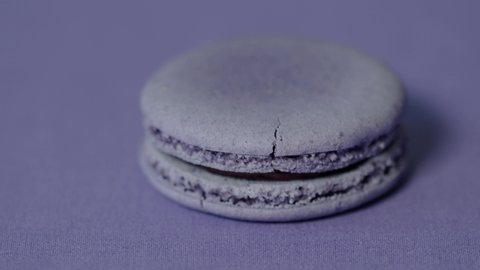 Vertical Move on Macaroon trendy color almond cake on top background. Color of the year 2022 concept. Shades lilac, purple, lavender. French dessert. Inspired by 17-3938
