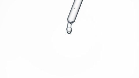 Macro shot of drop of grey fluid is falling down from pipette on white background. Abstract body care serum with hyaluronic acid formulation concept