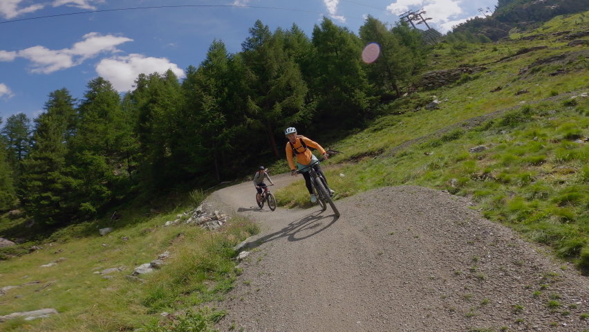 Mountain bikers riding down a pathway in the mountains. Rider point of view, mountain biking on high mountain terrain 
