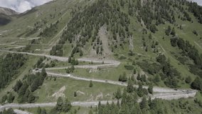 Reverse plane drone video over meandering climb of the stelvio pass