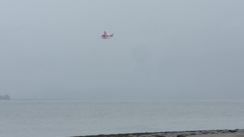 Float Plane Flying Over Fjord In Alaska On A Foggy Morning. tracking shot