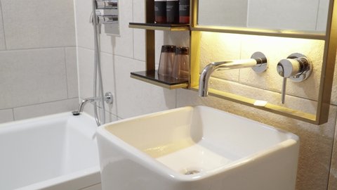 Bathroom Of A Luxury Hotel With Washbasin And Bathtub. Modern Bathroom Interior Design. panning left