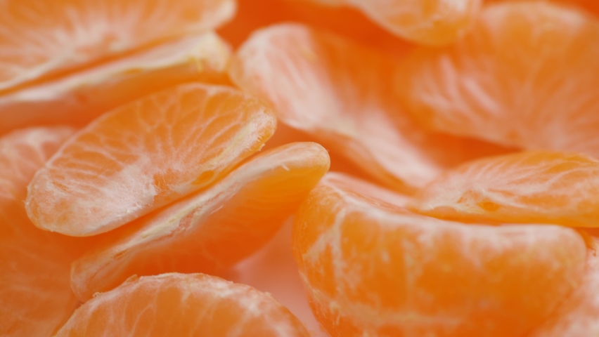 Tangerine slices close-up. Camera moves along peeled pieces of tangerine Royalty-Free Stock Footage #1084627645