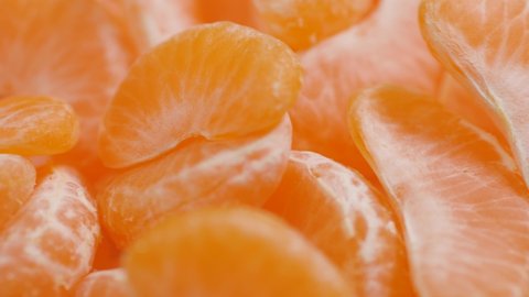 Tangerine slices close-up. Camera moves along peeled pieces of tangerine