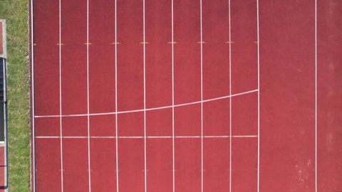 DRONE AERIAL FOOTAGE: The Manuela Machado Municipal Stadium, in Viana do Castelo, Portugal. Empty red running sports tartan track synthetic rubber on the athletic stadium.