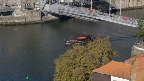 View on a traditional boat with tourists sailing the Douro river seen from the cable car in the center of Porto, Portugal, November 9 2021