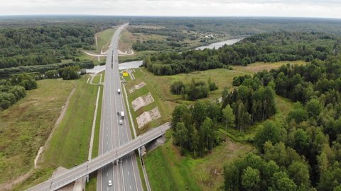 federal Highway bridge river in summer forest. modern straight road track. Moscow Saint Petersburg motorway M11 Neva in Russia. Aerial drone view. Flying over. Drone is standing