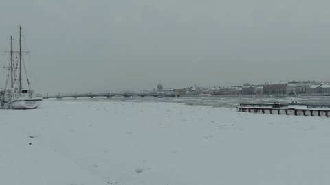 Russia, St. Petersburg, 07 December 2021: Slow motion footage of winter view of St. Petersburg at snow storm, frozen Neva river, steam over city, Isaac cathedral, car traffic on Blagoveshenskiy bridge
