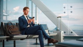 Airport Terminal Flight Wait: Smiling Businessman Uses Smartphone for e-Business, Browsing Internet with an App. Traveling Entrepreneur Work Online on Mobile Phone in Boarding Lounge of Airline Hub - Powered by Shutterstock - Get 15% off with code: PIKWIZARD15
