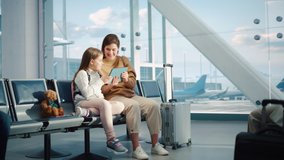 Busy Airport Terminal: Cute Mother and Little Daughter Wait for their Vacation Flight, Play Educational Games on Digital Tablet. People Sitting in Boarding Lounge of Airline Hub with Airplanes Flying - Powered by Shutterstock - Get 15% off with code: PIKWIZARD15