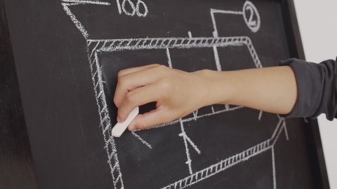 Close up of unrecognizable architect or engineer drawing construction scheme on chalkboard