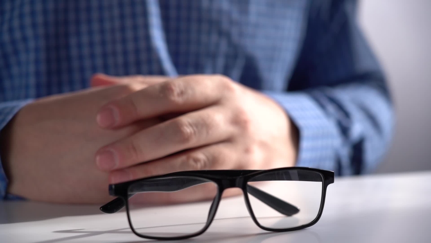 Man Takes Glasses from Work Table. Office work.