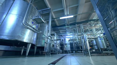 KYIV, UKRAINE - August 2021: Big room in the milk manufacturing factory. Stainless steel modern equipment for dairy production. View from below.