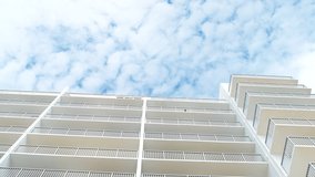 Abstract view looking up panning on exterior architecture facade of art deco white vintage retro residential building apartment condo or hotel with balconies and windows, blue sky at Hollywood Beach - Powered by Shutterstock - Get 15% off with code: PIKWIZARD15