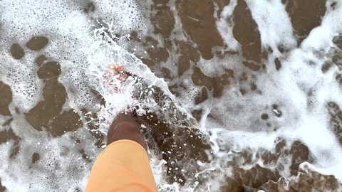 Man point of view at beach water. POV walking at sea shore