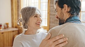 Sincere mother love. Happy grey-haired senior woman embracing her adult son, greeting him at home interior, close up, tracking shot, slow motion - Powered by Shutterstock - Get 15% off with code: PIKWIZARD15