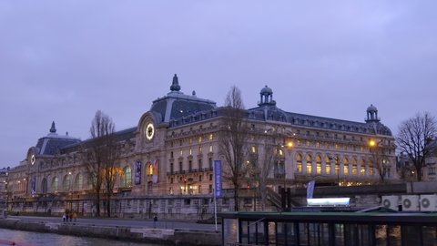 Paris, France - December 2021 : Orsay museum at night seen from a Bateau Mouche cruising on the river seine