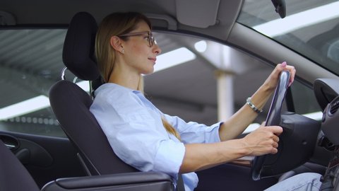 Young blond woman in stylish eyeglasses feeling sudden sharp pain in chest sitting in car, unfastening safety belt to breathing deeply and massaging chest, risk of heart attack, call 911