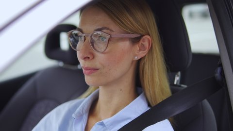 Exhausted blond woman in casual blue shirt taking off eyeglasses, touching temple feeling headache or dizziness, resting in car after hard working day, emotional burnout, stressful job, overworking