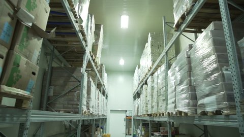 Yerevan, Armenia - September, 2021: Boxes of groceries in a industrial food large cold storage safety refrigerators. Panoramic shot. Slow Motion 