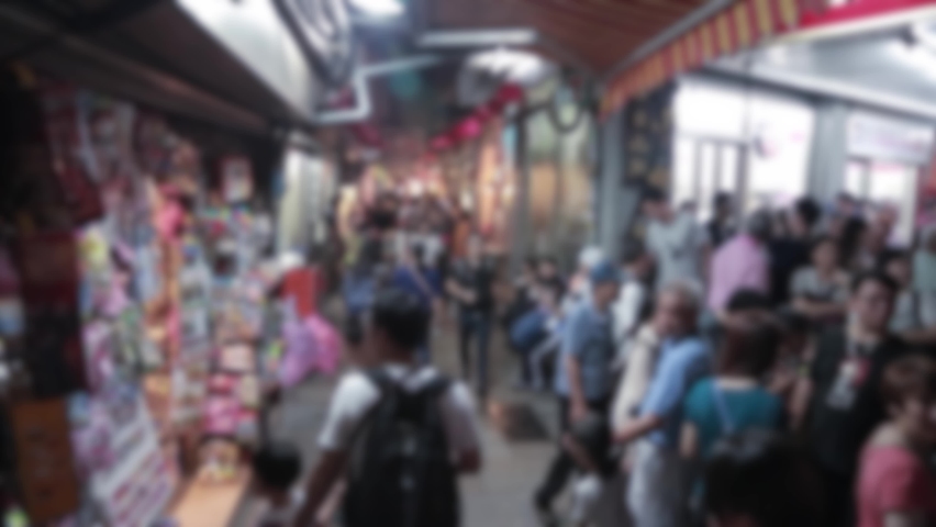 Blurred defocused view of people walking and shopping in Night market of Jiufen Old Street, famous marketplace with very diferent stores Chiufen city near Keelung, Taiwan.