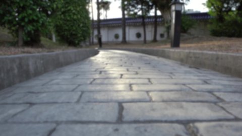 Defocused shot of paving stone road. Old pavement of square cobblestone sidewalk in Taipei. Garden patio in backyard stone brick pavers in Taiwan. Concrete paver block floor for background.