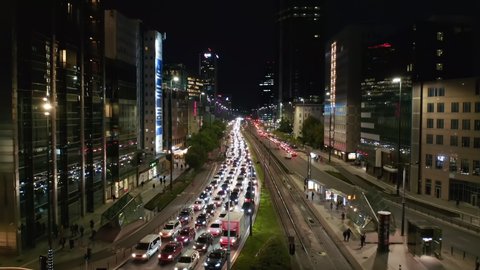 Ascending footage of traffic jam in multilane road. Long standing queue of cars leading through nigh city. Warsaw, Poland
