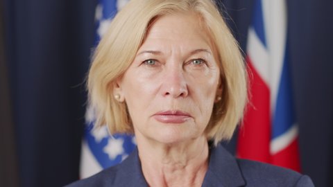 Slowmo closeup portrait of serious female political leader of Caucasian ethnicity looking at camera