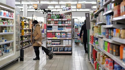 READING, UK - DECEMBER 30, 2021: Customers in the aisles of Sainsbury’s Supermarket in Reading, Berkshire, UK.
