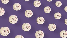 Colorful pattern of donuts isolated on purple background with shadows. Seamless pattern with donut. Doughnuts. Top view. Realistic animation. 4K video motion