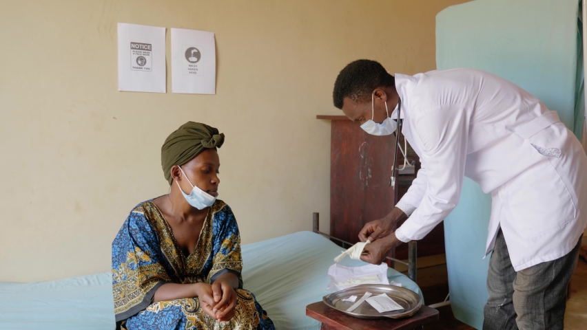 Wide shot of an African doctor putting on gloves in a rural clinic in Africa. Royalty-Free Stock Footage #1084662079