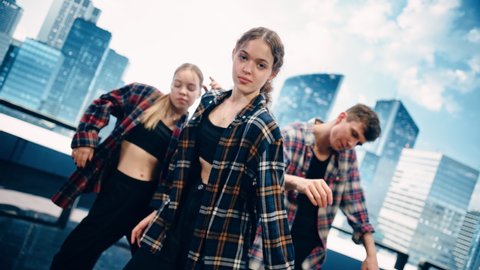 Diverse Group of Three Professional Dancers Performing a Slow Improvisation Dance Routine in Close Up in Front of a Big Led Screen with City Skyline with Office Skyscrapers in Studio Environment.