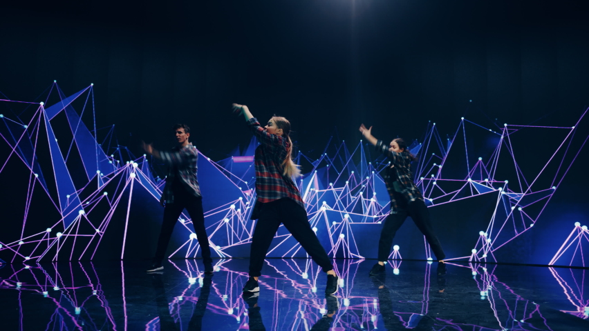 Diverse Group of Three Professional Dancers Performing a Hip Hop Dance Routine in Front of a Big Led Wall Screen with VFX Animation During a Virtual Production in Studio Environment. 105 BPM Song. Royalty-Free Stock Footage #1084666762