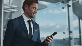 Airport Terminal: Businessman Walks to His Flight Gates, Uses Smartphone, Doing e-Business, Browsing the Internet with App. Digital Entrepreneur Remote Work Online While Traveling Through Airline Hub - Powered by Shutterstock - Get 15% off with code: PIKWIZARD15