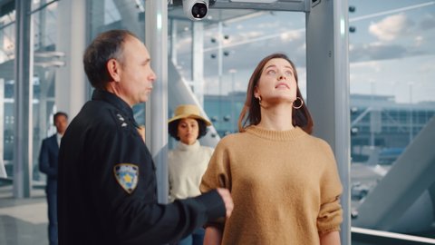 Airport Terminal: Security Officer Checks and Separates Diverse Group of People Walking Through Metal Detector Scanner Gates for Plane Flight Boarding. Crowd of Travelers Going on Vacation Trips
