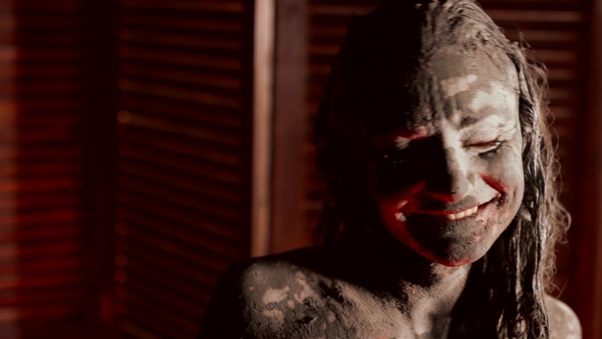 art performance of strange young woman, lady in mud is posing emotionally, portrait shot