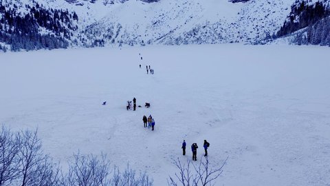 Zakopane, Poland - December 28, 2021: Tourists on frozen Morskie Oko lake in Tatra mountains in winter.