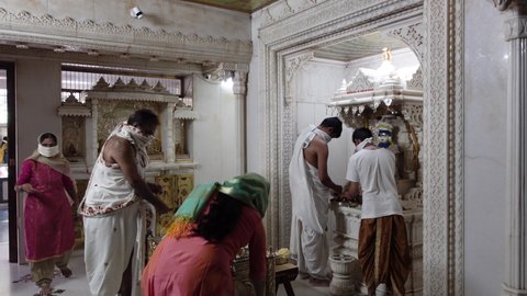Mumbai, India 11th December 2021:   Jain temple. Jainism. Pooja in Jain Derasar. Murti pooja. Using Chandan kesar on Idols of stone carved jain tirthankar.