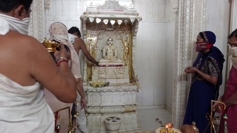 Mumbai, India 11th December 2021:   Jain temple. Jainism. Pooja in Jain Derasar. Murti pooja. Using Chandan kesar on Idols of stone carved jain tirthankar.