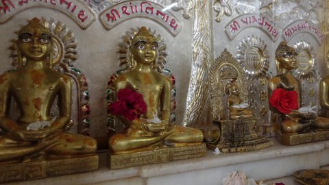 Mumbai, India 11th December 2021:   Jain temple. Jainism. Pooja in Jain Derasar. Using Chandan kesar on Idols of stone carved jain tirthankar.