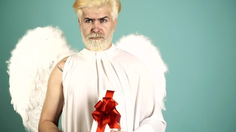 Funny angel cupid valentine with gift. Funny bearded man with feathers wings of Cupid Valentines Day. Humor comical concept.