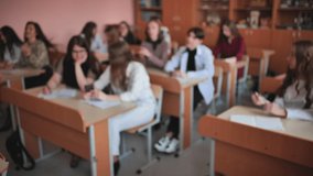 Pupils of the 11th grade in the class at the desks during the lesson. Blurred video.