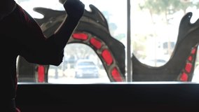 A man in a karate outfit prepares to train in front of a large bright window, silhouette of a martial artist - Powered by Shutterstock - Get 15% off with code: PIKWIZARD15