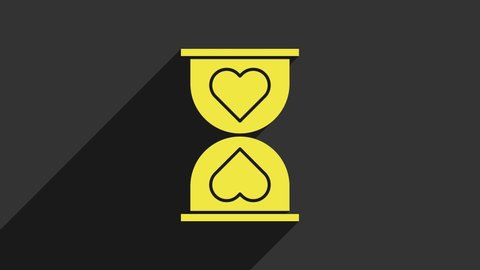 Yellow Heart in the center old hourglass icon isolated on grey background. Valentines day. 4K Video motion graphic animation.