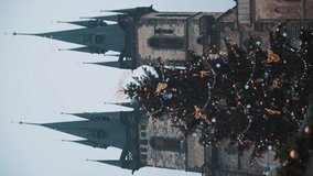 Vertical video. Central square in Prague castle. Big christmas tree with lots of decorations in front of cathedral celebrating holiday season. Beautiful view on famous city landmark during holidays.
