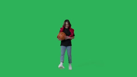 young beautiful girl dancing hip hop, dancehall, street dance over green screen background. Happy smiling child having fun with basketball on Chroma Key. 4k uhd video footage