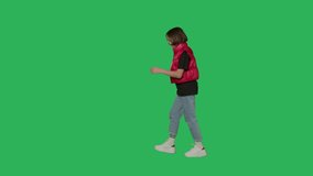 Teen girl walking on Green Screen, Chroma Key. Side view 4k uhd video footage